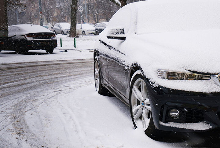 Verschneites Auto auf Straße