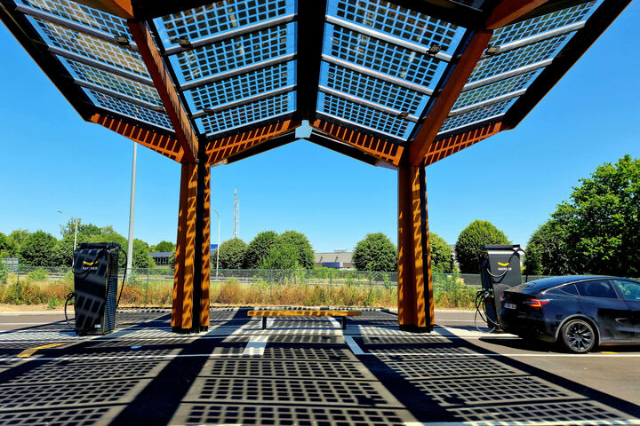 Elektroauto wird unter Photovoltaik-Modulen geladen